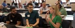 A woman enthusiastically converses with other participants at a conference